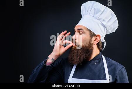 Chef, cuoco, panettiere gesturing eccellente. Chef professionista in uniforme mostra gesto perfetto gustoso segno gustare il pasto. Foto Stock