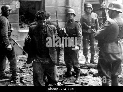 Warsaw Ghetto Uprising- le truppe d'assalto delle SS catturano due combattenti della resistenza ebraica tirati da un bunker durante la soppressione della rivolta del ghetto di Varsavia ca. 1943 Foto Stock