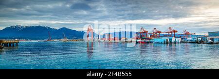 Spettacolare panorama del Porto di Vancouver, le prime mattine con le nuvole. Scena lungomare con edifici industriali, gru, container, grande autocisterna, b Foto Stock