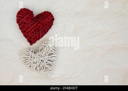 Due cuore decorativo in vimini su uno sfondo chiaro con posto per il testo. Foto Stock