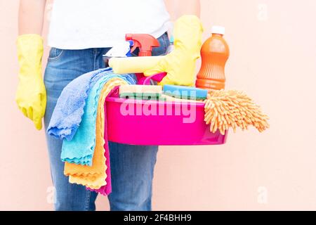 donna caucasica che tiene il bacino con i rifornimenti di pulizia Foto Stock