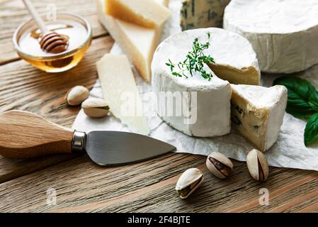 Vari tipi di formaggio, formaggio blu, bree, camambert su un tavolo di legno Foto Stock