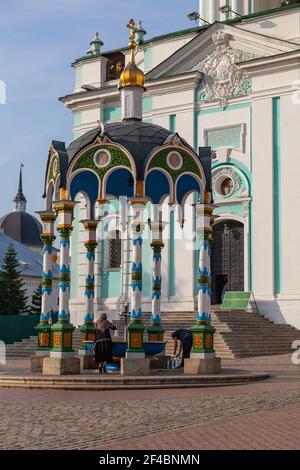 Un uomo e una donna raccolgono acqua da una sorgente Santa nella Lavra Trinità-Sergius, Russia Foto Stock