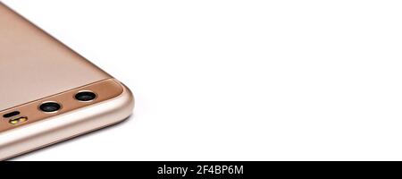Dettaglio closeup di obiettivi a doppia fotocamera sulla parte inferiore del telefono cellulare color oro rosa, sfondo bianco isolato, spazio per il testo sul lato destro Foto Stock