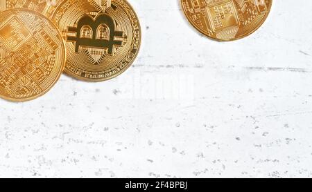 Vista dall'alto, btc commemorativa d'oro - criptovaluta bitcoin - monete su tavola di pietra bianca, dettaglio closeup, spazio per il testo in basso a destra Foto Stock