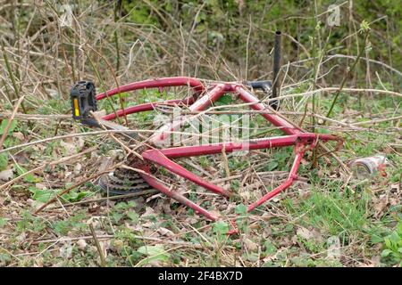 Vola in campagna. Telaio della bicicletta abbandonato sul lato della strada. Foto Stock