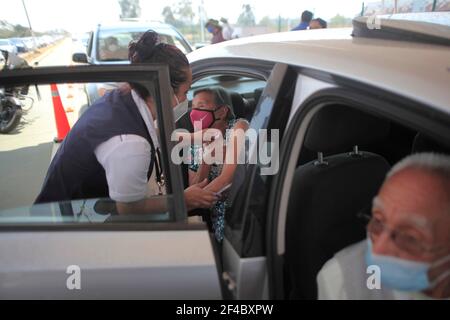 Città di Nezahualcoyotl, Messico. 19 marzo 2021. NEZAHUALCOYOTL, MESSICO - MARZO 19: Un'infermiera somministra la dose di Coronavac Covid-19 a un anziano a bordo di un'auto, durante un programma di vaccinazione di massa in un sito di vaccinazione drive-thru gestito dal Dipartimento di Sanità di Nezahualcoyotl. Si prevede l'applicazione di 40,000 dosi per immunizzare adulti di età superiore ai 60 anni durante una campagna di vaccinazione COVID-19. Il 19 marzo 2021 a Nezahualcoyotl City, Messico (Foto di Eyepix Group/Pacific Press) Credit: Pacific Press Media Production Corp./Alamy Live News Foto Stock