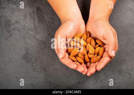 Prunus dulcis - mani che tengono mandorle pelate Foto Stock