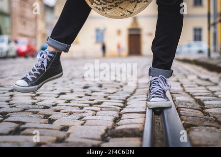 La donna indossa scarpe da ginnastica e cammina per la strada. Gambe umane con scarpe in tela. Foto Stock