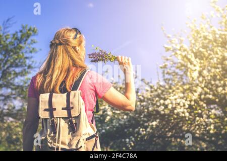 Benvenuti in primavera. La donna caucasica felice sta godendo la primavera nel frutteto fiorente. Donna che si sente libera. Immagine a toni Foto Stock