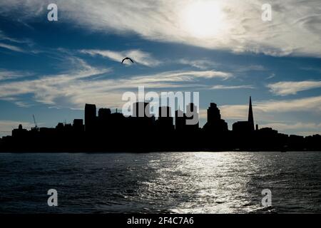 Lo skyline di San Francisco si presenta come il sole tramonta sulla Baia di San Francisco. Foto Stock