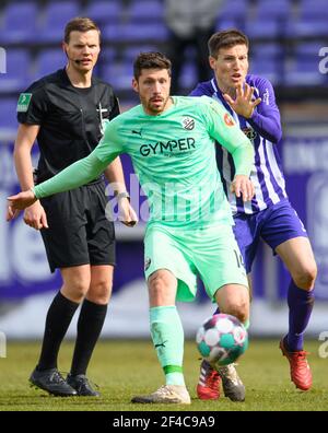 Aue, Germania. 20 Marzo 2021. Calcio: 2. Bundesliga, FC Erzgebirge Aue - SV Sandhausen, Matchday 26, a Erzgebirgsstadion. Tim Kister di Sandhausen (l) contro Gaetan Bussmann di Aue, dietro l'arbitro Thorben Siewer. Credito: Robert Michael/dpa-Zentralbild/ZB - NOTA IMPORTANTE: In conformità con le norme del DFL Deutsche Fußball Liga e/o del DFB Deutscher Fußball-Bund, è vietato utilizzare o utilizzare fotografie scattate nello stadio e/o della partita sotto forma di sequenze fotografiche e/o serie fotografiche di tipo video./dpa/Alamy Live News Foto Stock