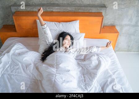 Donna asiatica si sveglia nella camera da letto. Si sentiva molto rinfrescata. Foto Stock