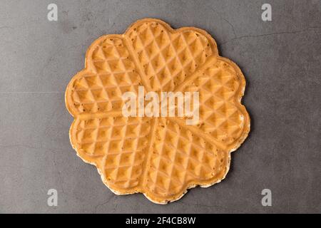 Cialda a cuore singolo su sfondo di pietra scuro. Foto Stock