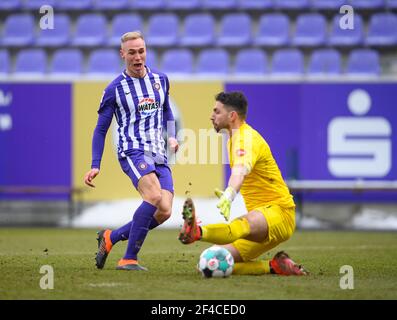 Aue, Germania. 20 Marzo 2021. Calcio: 2. Bundesliga, FC Erzgebirge Aue - SV Sandhausen, Matchday 26, a Erzgebirgsstadion. Florian Krüger di Aue (l) contro Stefanos Kapino, portiere di Sandhausen. Credito: Robert Michael/dpa-Zentralbild/dpa - NOTA IMPORTANTE: In conformità con le norme del DFL Deutsche Fußball Liga e/o del DFB Deutscher Fußball-Bund, è vietato utilizzare o utilizzare fotografie scattate nello stadio e/o della partita sotto forma di sequenze fotografiche e/o serie fotografiche di tipo video./dpa/Alamy Live News Foto Stock