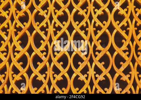 Primo piano di una griglia ornata rivestita in oro forgiato di condotto d'aria in stile arabo. Motivo floreale orientale della griglia di ventilazione. Foto Stock