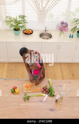 Vista ad alto angolo della madre afroamericana che insegna la cucina della figlia in cucina Foto Stock