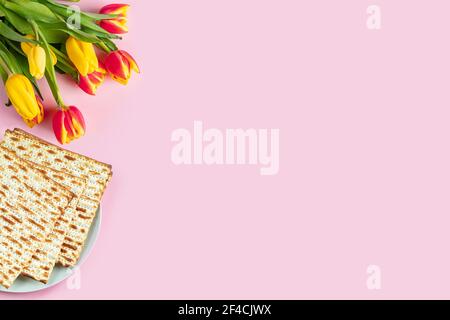 Banner di buona Pasqua. Mazzo e un bouquet di tulipani colorati su sfondo rosa. Tradizionale cibo ebraico per Pesach. Spazio di copia. Foto Stock