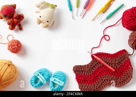 Colorato crochet progetto con gancio e filo, su sfondo bianco. Foto Stock