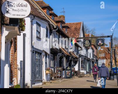 Pinner Village High Street. Storico Queen’s Head Pub, Frisolin’s Beauty Clinic, Pizza Express Old Village panetteria edificio. Persone che camminano per strada. Foto Stock