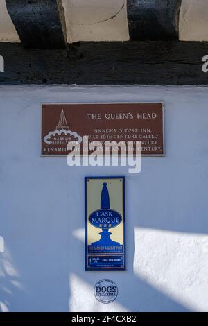 Cartelli sul Queen’s Head Historic Pub e la più antica locanda di Pinner, costruita nel XVI secolo. Premio pub Cask Marque, benvenuto ai cani e Harrow Heritage Trust. Foto Stock