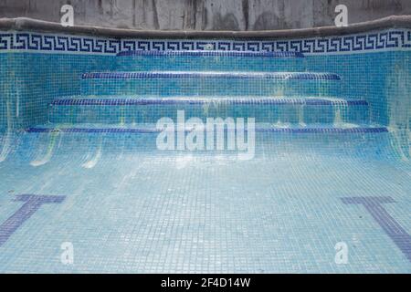 Piastrelle blu scala piscina scala senza acqua con resti di acido cloridrico. Foto Stock