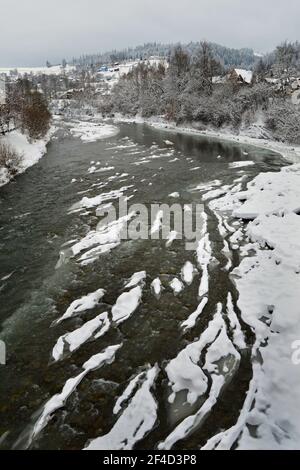 Il fiume Cheremosh nero di Verkhovyna è coperto di ghiaccio e neve. Ucraina Foto Stock