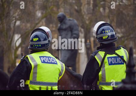 Londra, Regno Unito. 20 marzo 2021. Ha montato la polizia accanto alla statua di Winston Churchill a Parliament Square durante la protesta anti-blocco nel centro di Londra. Credit: Vuk Valcic/Alamy Live News Foto Stock