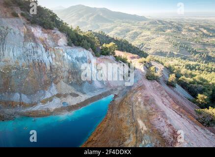 Vista aerea della miniera abbandonata di Alestos a Cipro. Lago blu e rocce colorate ricche di depositi di rame e solfuro Foto Stock