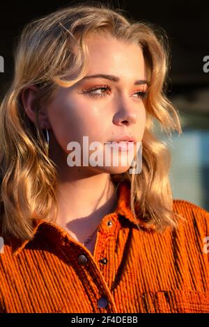 Ritratto di una bella donna in giardino con luce solare sul viso Foto Stock