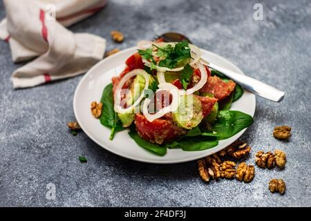 Insalata georgiana di pomodoro, cetriolo e cipolla con condimento di noce e noci fresche Foto Stock