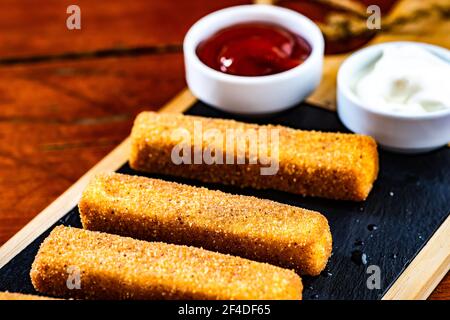 Bastoncini di formaggio fritti con ketchup e maionese Foto Stock