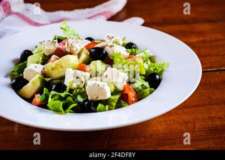 Ciotola di insalata greca su un tavolo di legno Foto Stock