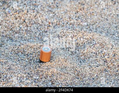 Batterie smaltite in modo non corretto nella sabbia sulla spiaggia.batterie usate di scarto. Concetto di inquinamento ambientale. Foto Stock