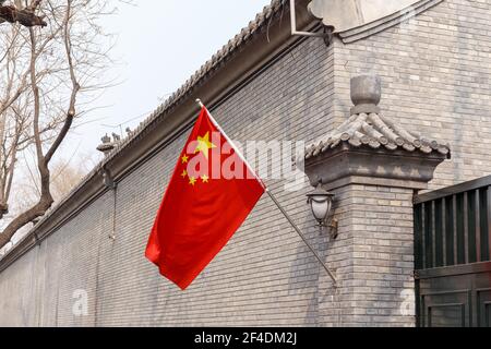 Bandiera cinese su un vecchio muro vicino alla Città Proibita a Pechino, Cina nel marzo 2018. Foto Stock