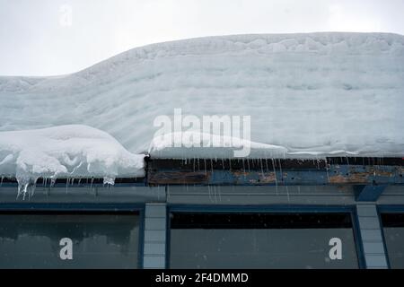 Neve estremamente spessa e icicletta accumulata sul tetto di un edificio nella British Columbia, Canada Foto Stock