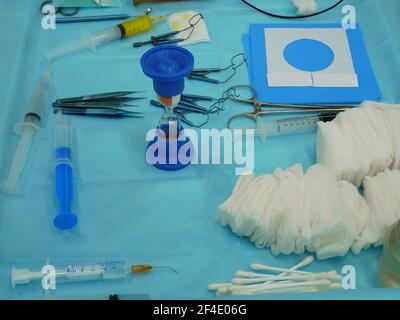 Set di vari piccoli strumenti medici sterili e accessori sono disposti su un tavolo nella sala operatoria, primo piano Foto Stock