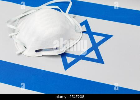 Bandiera di Israele e maschera facciale N95. Concetto di Covid-19 coronavirus blocco, divieto di viaggio e crisi sanitaria Foto Stock