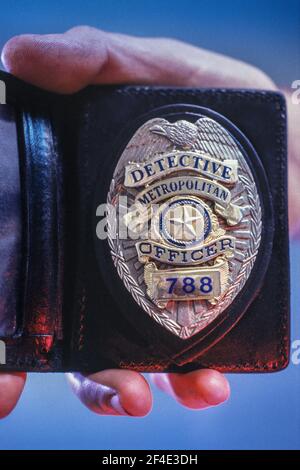 Badge della polizia e sostegno al portafoglio, con la mano Foto Stock