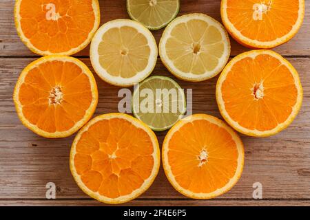 Arance, lime e limoni scivoli su tavola di legno vista da sopra.Beautiful Sfondo con frutta fresca metà cut.Healthy mangiare vitamina C.Summer tropica Foto Stock