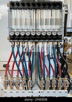 circuito con tubi flessibili blu e rossi che collegano tubi di prova graduati con manometri e regolatori di temperatura, sistema di raffreddamento stampo pressofuso, automatico Foto Stock