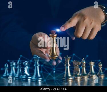Uomo d'affari mano che sposta il cavaliere d'oro scacchi combattendo cavaliere d'argento con fuoco scintilla scacchi sulla scacchiera per riuscire nella competizione. Manag Foto Stock