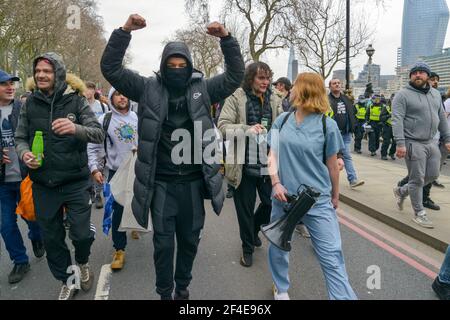 Un protestore che marciare mentre gesturing durante la dimostrazione. Migliaia di persone si erano riunite illegalmente per una dimostrazione anti-blocco a Londra, violando le regole di blocco nazionali. Foto Stock