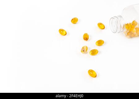 Capsule di olio di pesce di colore giallo con flacone di vetro su fondo bianco. Foto Stock