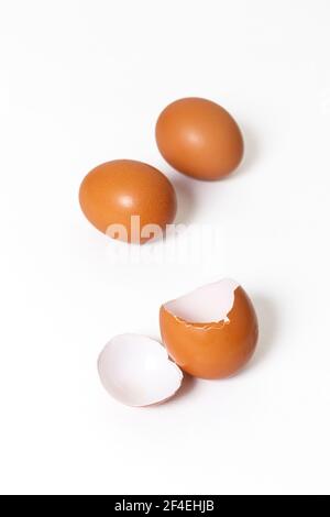 Pollo fresco uova intere e un uovo rotto isolato sopra sfondo bianco Foto Stock