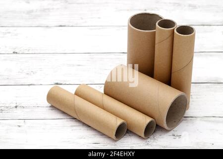 Fila di cilindri di cartone su un tavolo di legno bianco Foto Stock