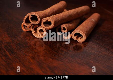 Primo piano di quills cannella o bastoni spezie cucina su uno sfondo in legno con spazio per la copia Foto Stock