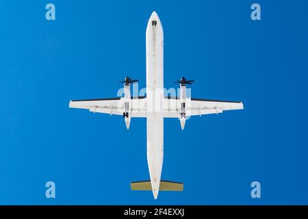 Velivolo turboprop con motori ad elica sulle ali prima dell'atterraggio una pista all'aeroporto contro un cielo blu Foto Stock