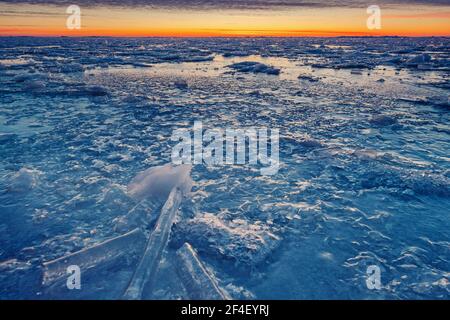 Splendidi colori del tramonto sul cielo e le nuvole. Modelli di ghiaccio e consistenza. Periodo invernale gelido. Foto Stock