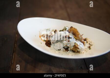 patate arrostite al forno con salsa di panna acida e erbe Foto Stock